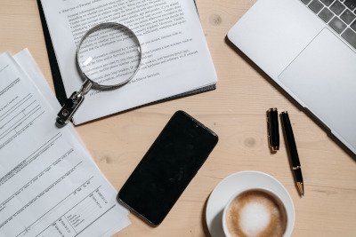 Vertragsdokument mit Stift und Lupe auf einem Schreibtisch