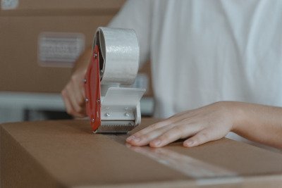 Versandkarton mit Paketband und Versandetikett auf einem Tisch